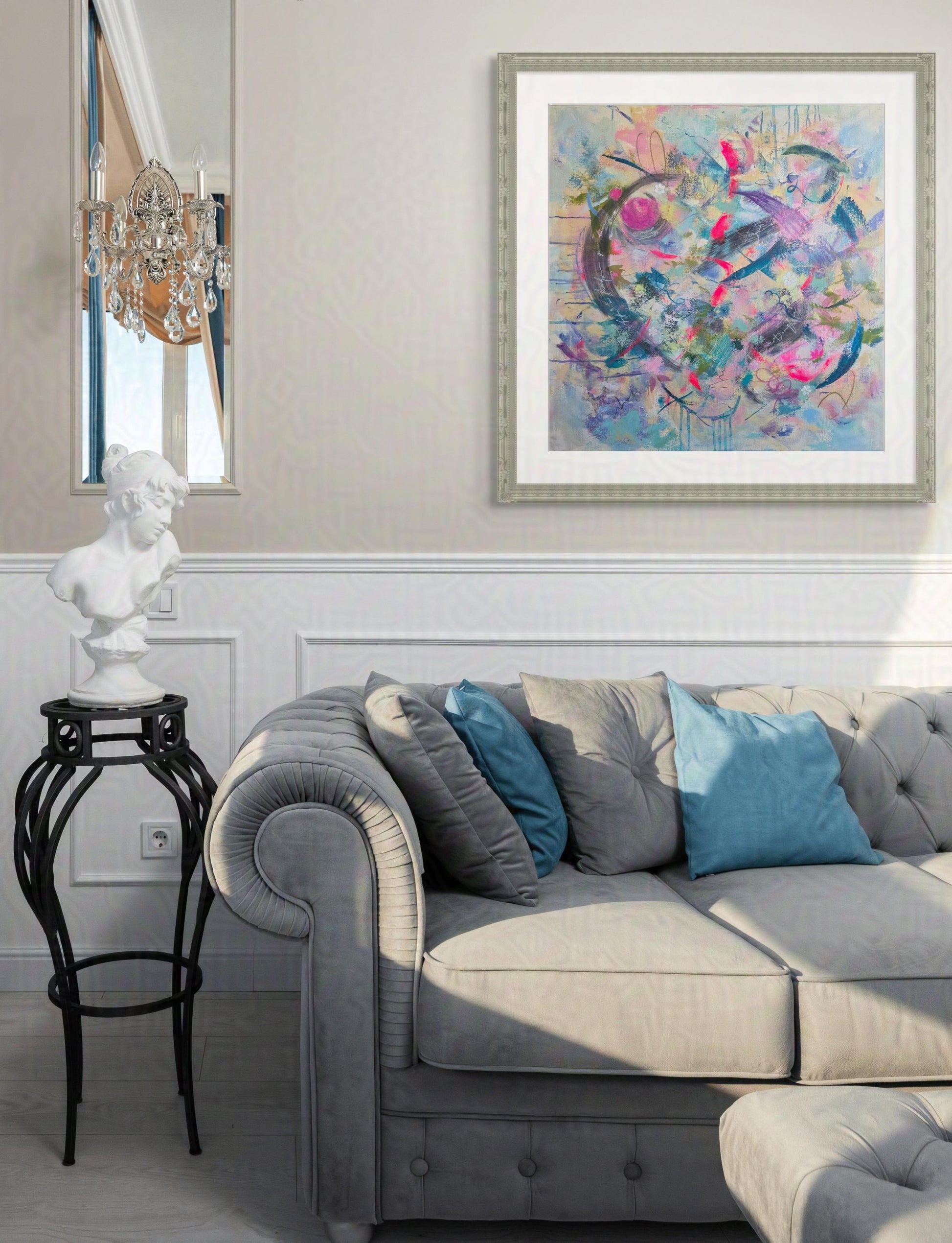Living room with a gray sofa, colorful abstract painting, and decorative items.
