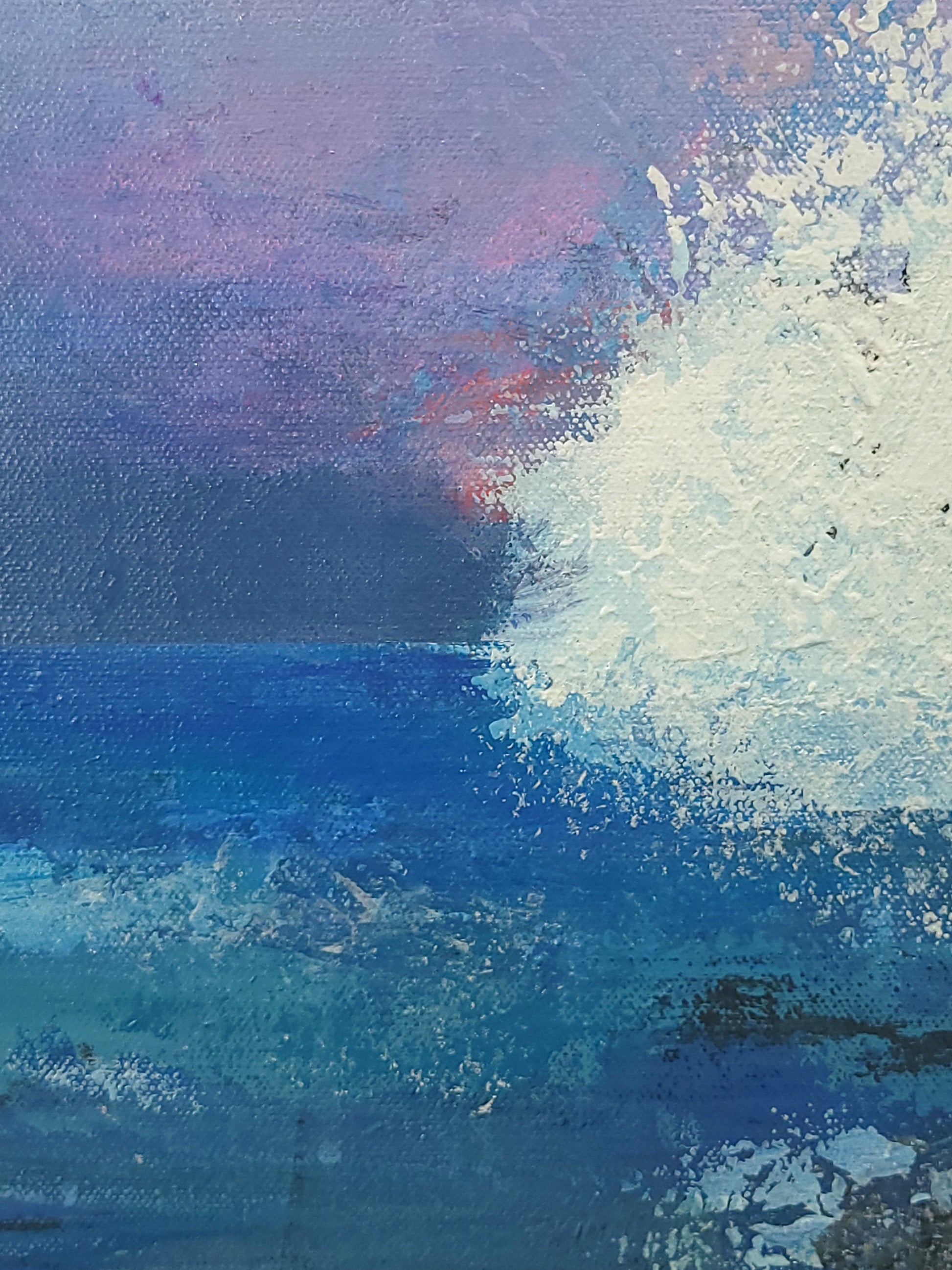 Detail of ocean, foam from a breaking wave, distance mountains, and sky